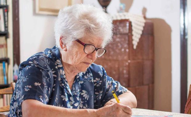 older women at home filing out paper