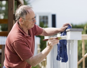 Senior Man Painting Deck doing minor home repairs