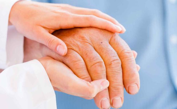 volunteer holding hand of a elderly person