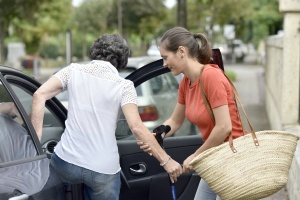 women helping elder take a senior transportation