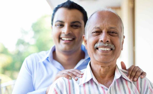 younger man volunteering with a older member smiling