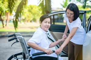 Caregiver helping women into car
