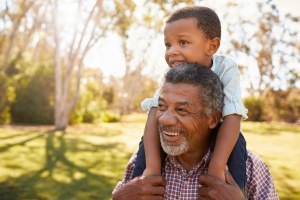 grandfather with his son while smiling at caregiver who is  Caring For The Elderly
