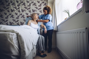 Senior Care Options helping a senior woman get dressed in her bedroom