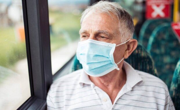 senior man with protective face mask in bus transport