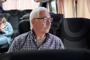 senior passenger in glasses sitting i modern bus