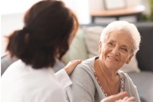 doctor talking to old patient at home for at home senior care services