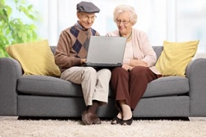 old couple sitting on sofa with a aging in place checklist