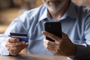 old man paying with debit card for Senior Service