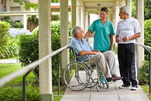 senior citizens talking to a nurse in a hospital garden during Senior Service