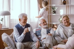 old mens in care facility while nurse in background for a Senior Check In