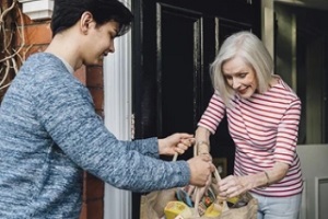 volunteer delivering food to old lady