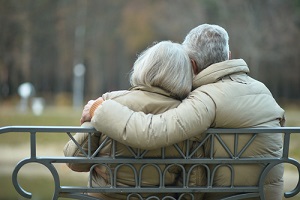 elderly couple resting at autumn park