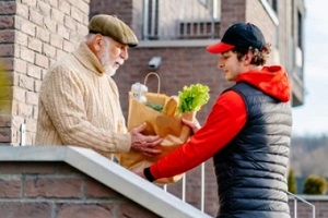 man delivering grocery to old man