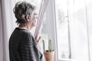 senior citizen lady lookin out of window
