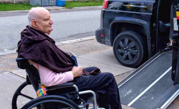 senior man in wheelchair waiting to go up ramp into wheelchair cab
