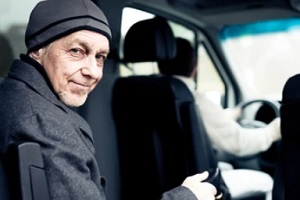 senior man sitting on the back seat of the car