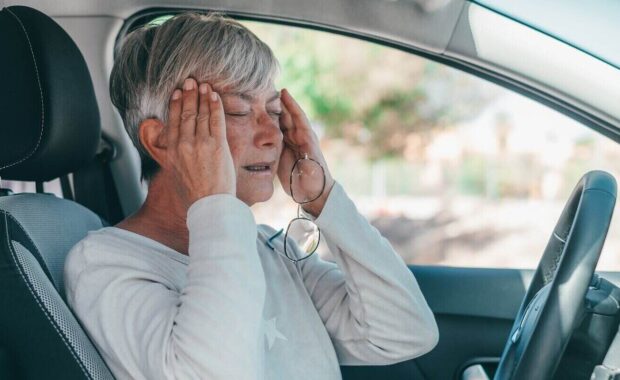 mature female people having and feeling bad headache in car while driving