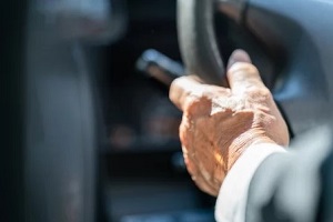 old man hand on steering wheel