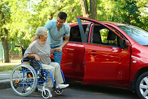 young senior transportation volunteer helping a elder women