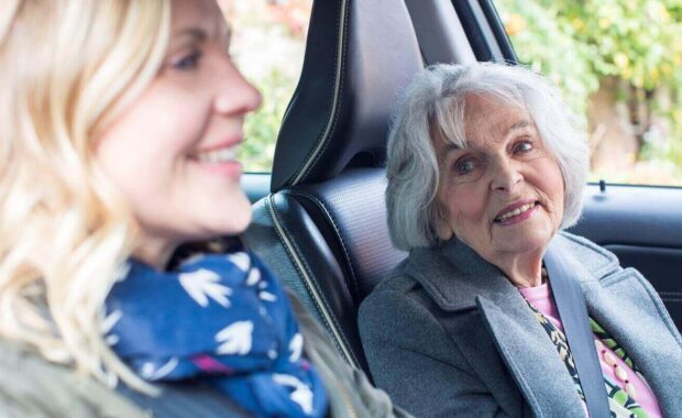 female neighbor giving senior woman a lift in car