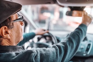 old driver setting rearview mirror