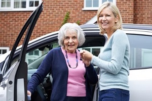 women helping old women getting out of the car