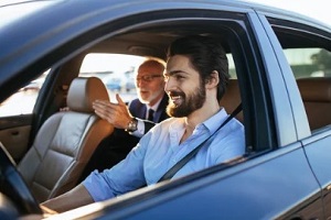 young man taking old man in car