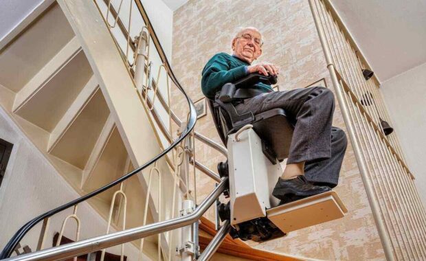 elderly man in the staircase using the stairlift