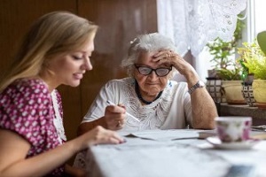 girl with old lady marking newspaper