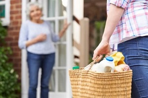 man delivering grocery to senior women