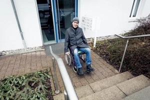 old man sitting on wheelchair outside the home