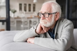 upset old man sitting in sofa