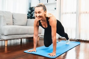 aging athlete senior woman doing exercise on fit mat with plank climbing at home exercise as concept of healthy fit body lifestyle after retirement