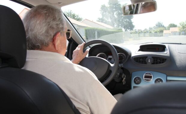 elderly person driving a car