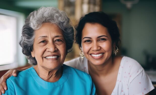 portrait of a young female caregiver with senior patient at home