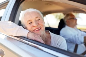 senior women smiling and looking out of car window