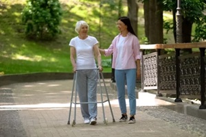 granddaughter supporting disabled grandma with walking frame