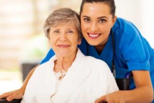 happy senior woman on wheelchair with caregiver