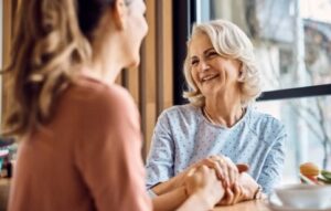 senior woman enjoys in conversation with her adult daughter in cafe