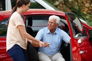 shot of a woman helping her senior father out of the car