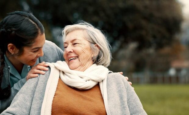 caregiver helping woman with disability in park for support, trust and care in retirement