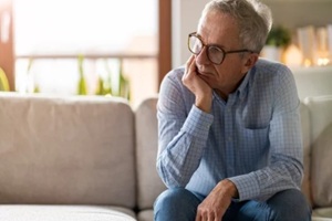 worried senior man sitting alone in his home