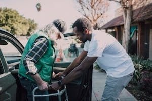 Driver Assisting Senior Person with Walker