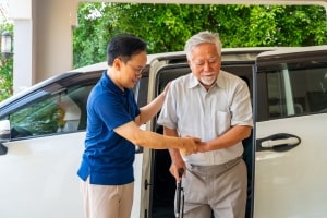 Driver Helping Old Man Get Out from Car
