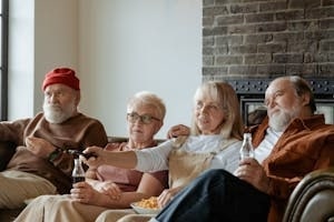 Old People Watching TV with Snacks and Cold Drinks