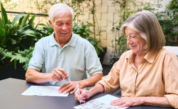 senior couple enjoying brain games together in a rehabilitation facility garden