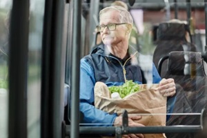old man with groceries travelling in a bus