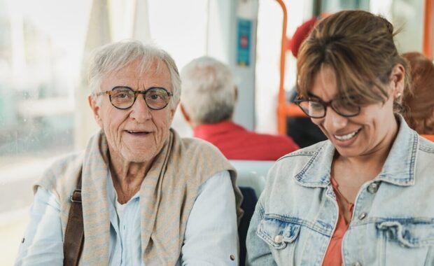 senior man sitting inside tram with adult daughter