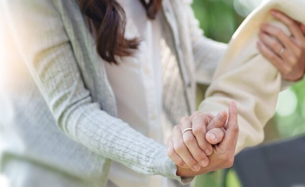young caregiver helping senior woman in wheelchair